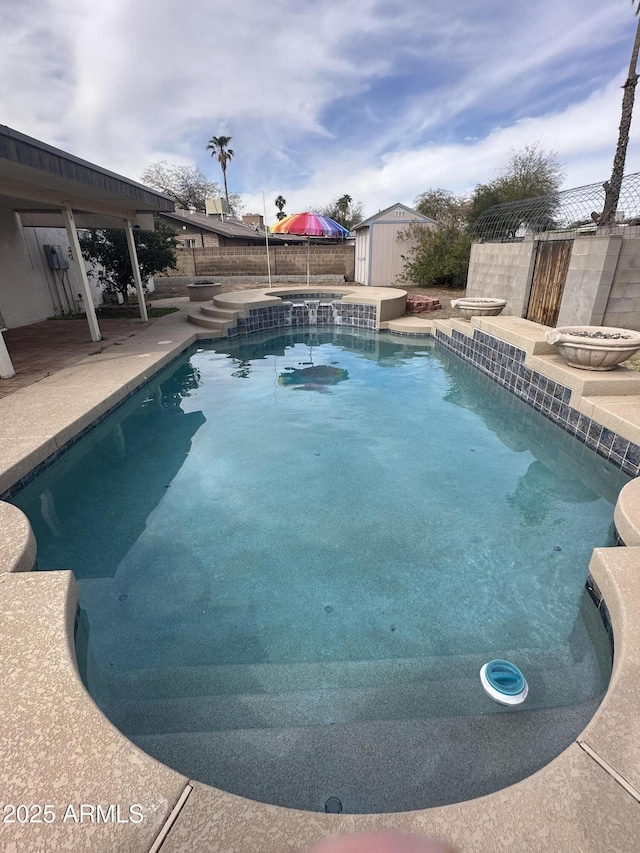 view of pool featuring an outbuilding, a fenced backyard, a fenced in pool, a shed, and a patio area