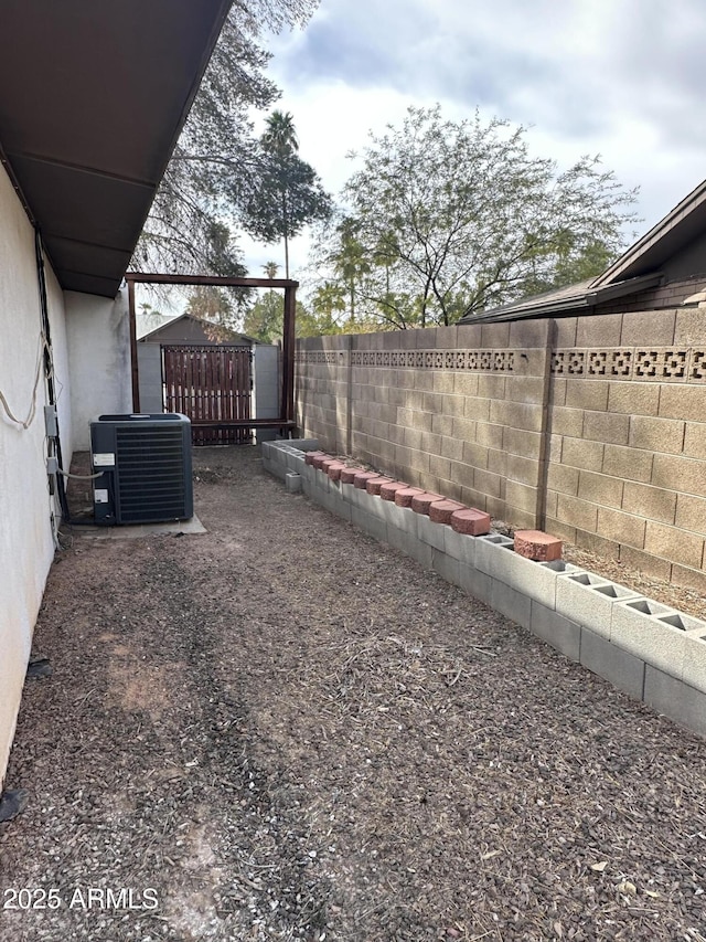 view of yard with central AC and a fenced backyard