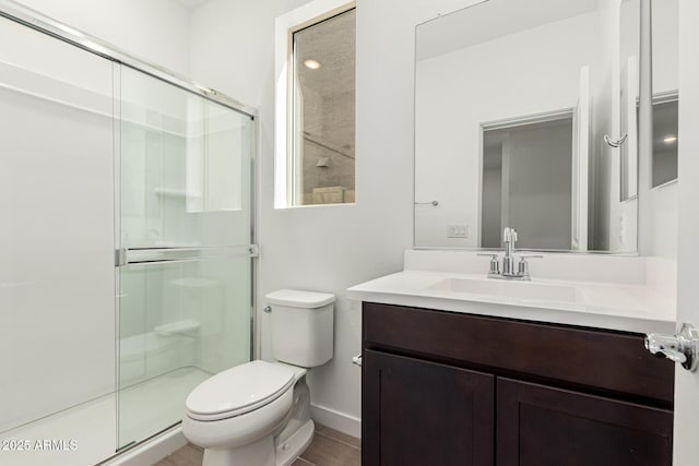 bathroom featuring vanity, toilet, and an enclosed shower