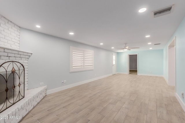 unfurnished living room featuring visible vents, a ceiling fan, recessed lighting, light wood finished floors, and a brick fireplace