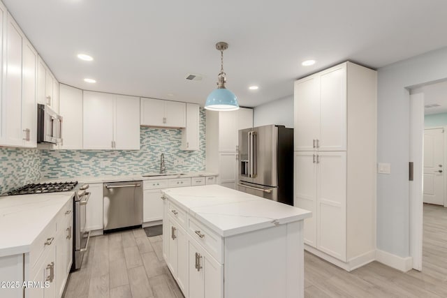 kitchen with visible vents, tasteful backsplash, white cabinetry, stainless steel appliances, and light wood finished floors