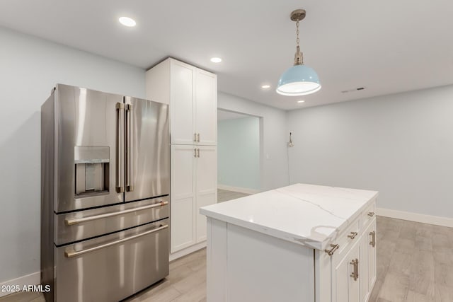 kitchen with visible vents, light wood-type flooring, light stone counters, stainless steel refrigerator with ice dispenser, and white cabinetry