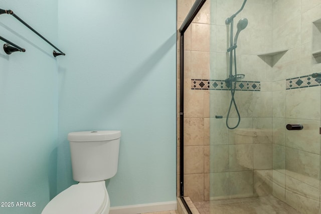 full bath featuring a stall shower, toilet, and baseboards