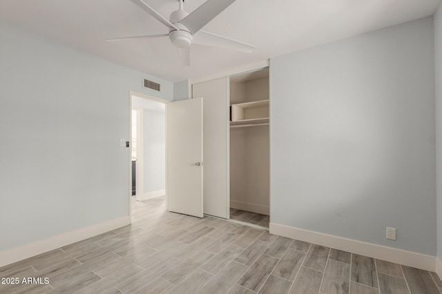 unfurnished bedroom with a closet, visible vents, baseboards, and wood finish floors