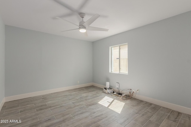 empty room featuring wood tiled floor, baseboards, and ceiling fan