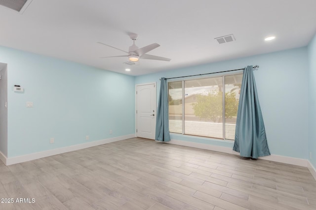 unfurnished room featuring light wood-style floors, a ceiling fan, visible vents, and baseboards