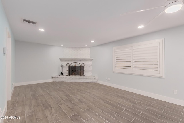 unfurnished living room featuring visible vents, a brick fireplace, baseboards, recessed lighting, and wood finished floors