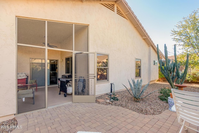 back of property with ceiling fan and a patio