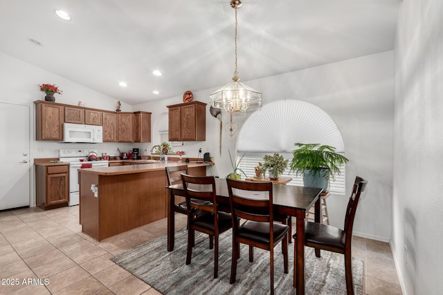 kitchen with decorative light fixtures, lofted ceiling, kitchen peninsula, white appliances, and a chandelier