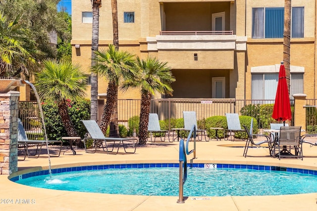 view of pool with pool water feature and a patio