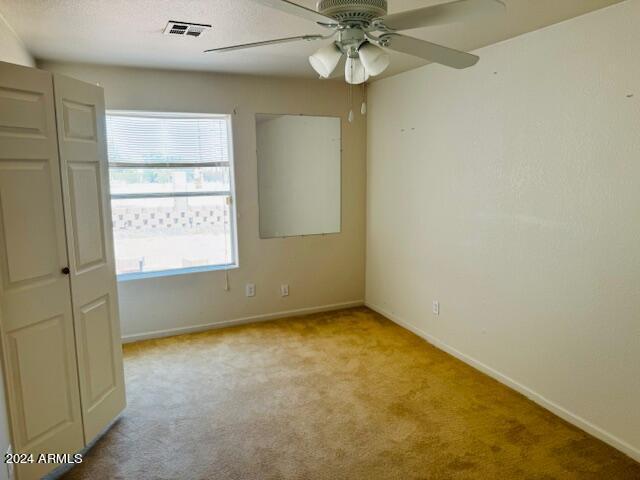 unfurnished bedroom featuring ceiling fan and light carpet