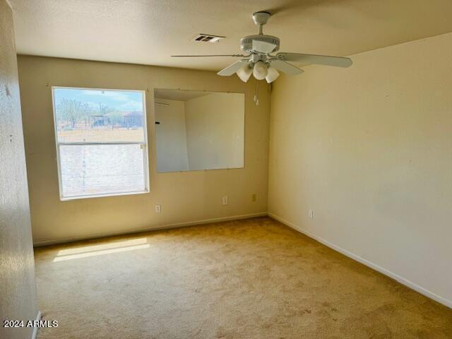 spare room with light colored carpet and ceiling fan