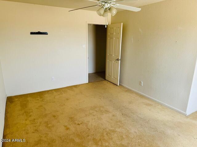 empty room with light colored carpet and ceiling fan