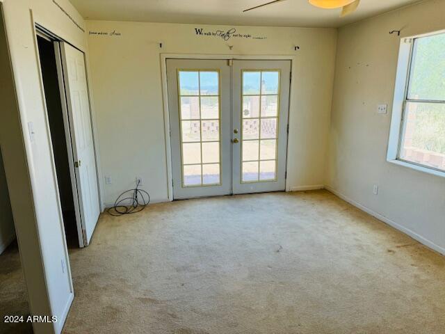 empty room with french doors and light colored carpet