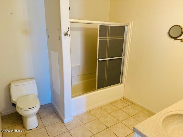 full bathroom featuring tile patterned flooring, vanity, toilet, and combined bath / shower with glass door