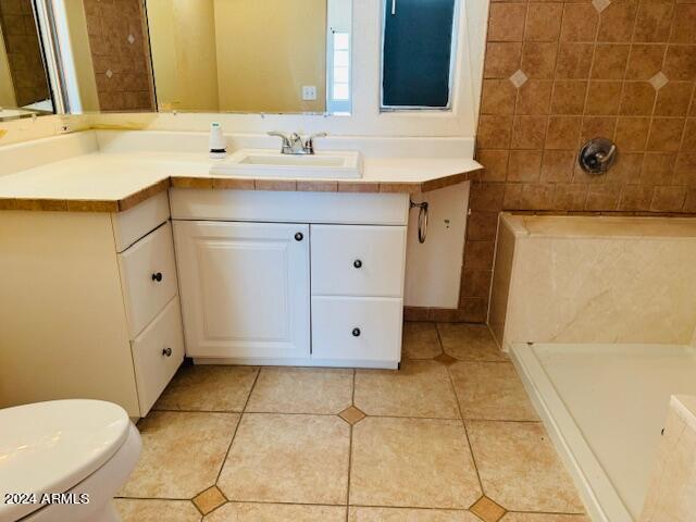 bathroom with tile patterned floors, walk in shower, toilet, and vanity