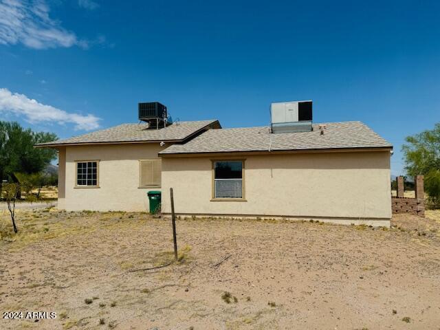 rear view of house featuring central air condition unit