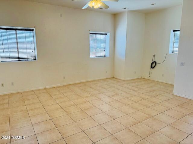 unfurnished room with light tile patterned floors and ceiling fan