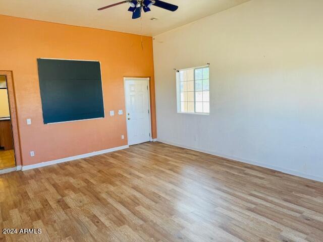 empty room with ceiling fan and light hardwood / wood-style floors