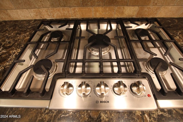 interior details featuring stainless steel gas stovetop and dark stone counters