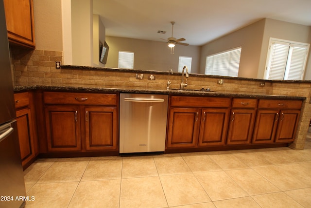 kitchen featuring ceiling fan, sink, dark stone countertops, light tile patterned floors, and appliances with stainless steel finishes