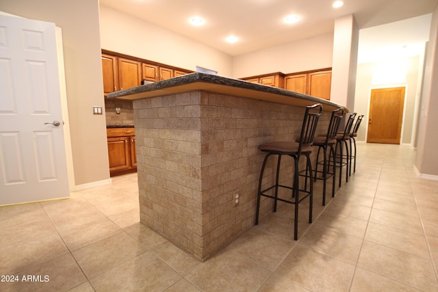 bar featuring decorative backsplash and light tile patterned floors