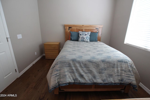 bedroom with dark hardwood / wood-style floors