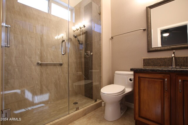 bathroom with tile patterned floors, toilet, an enclosed shower, and vanity