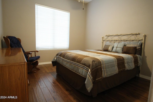 bedroom with dark hardwood / wood-style flooring