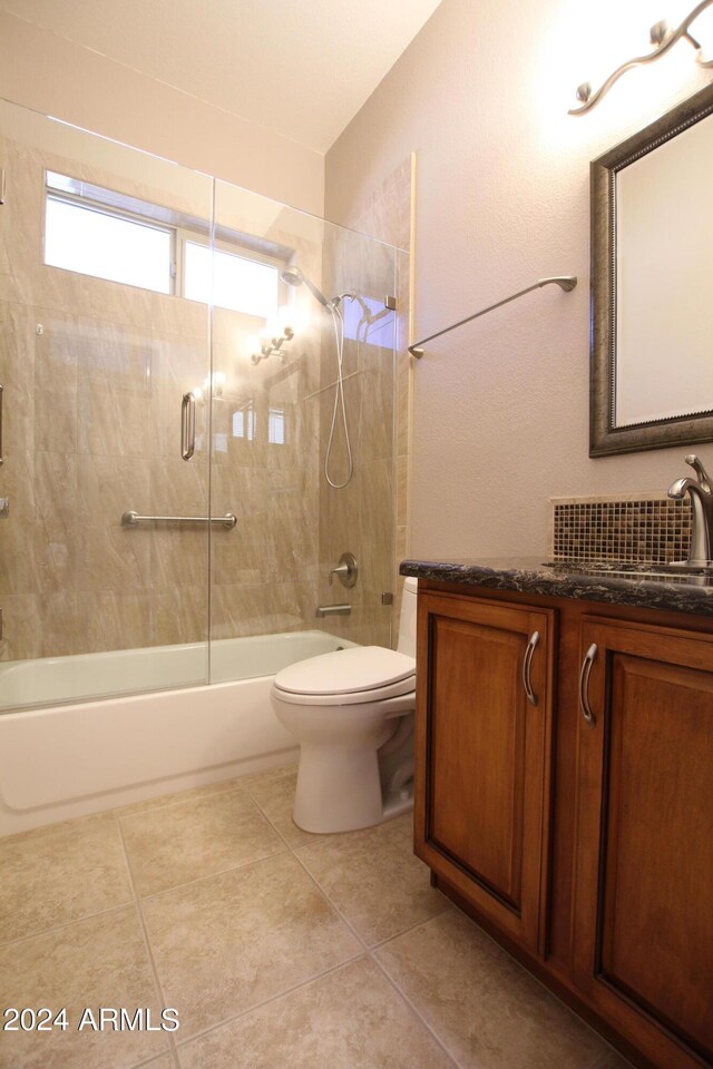 full bathroom featuring tile patterned flooring, enclosed tub / shower combo, vaulted ceiling, toilet, and vanity