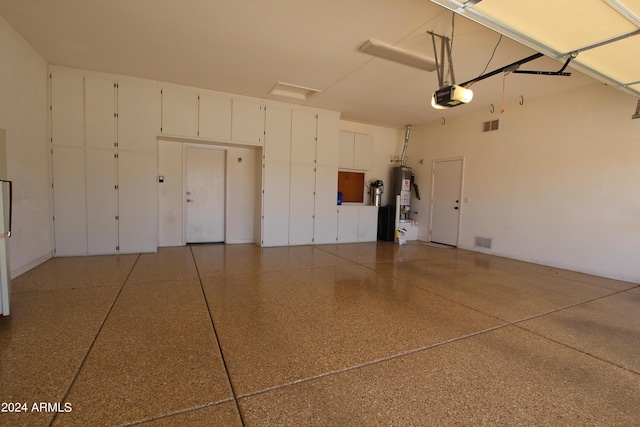 garage with gas water heater and a garage door opener