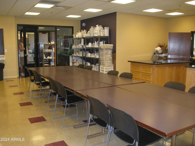 bar with a paneled ceiling and light brown cabinets