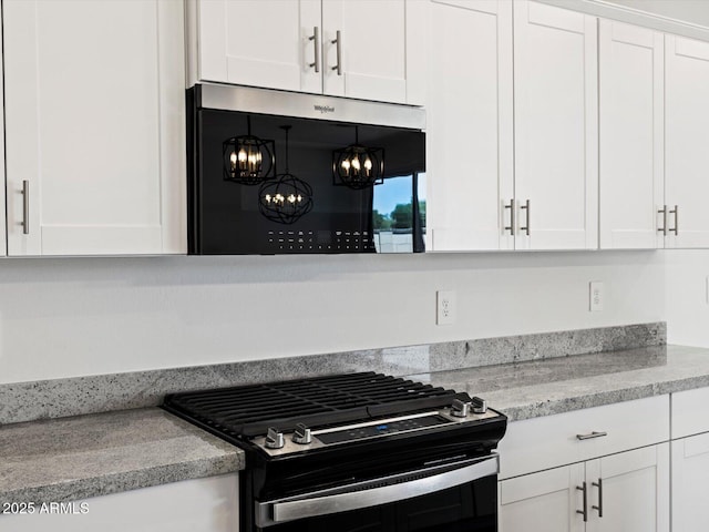 37357 W San Sisto Ave, Maricopa, AZ 85138 - kitchen with gas range oven, a chandelier, and white cabinetry