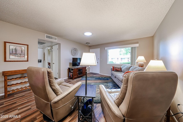 living room with hardwood / wood-style floors and a textured ceiling