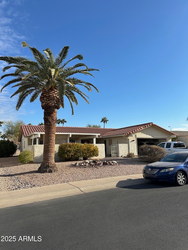 view of front facade with a garage, stucco siding, and a tiled roof