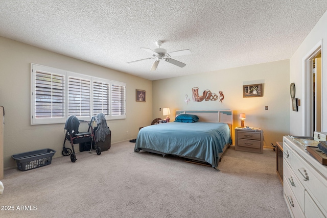 bedroom with light carpet, a textured ceiling, and a ceiling fan