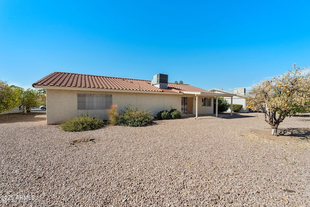 rear view of house featuring a tiled roof, a patio, central AC, and stucco siding