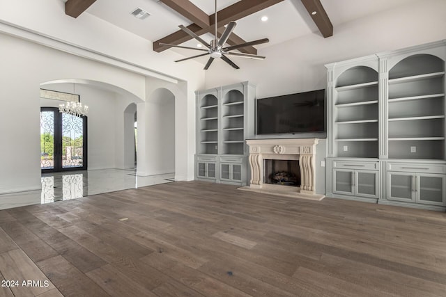 unfurnished living room featuring french doors, beamed ceiling, dark hardwood / wood-style floors, and ceiling fan with notable chandelier