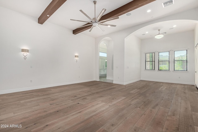 unfurnished living room featuring beamed ceiling, ceiling fan, and light hardwood / wood-style flooring