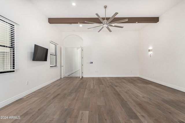 unfurnished living room with beamed ceiling, wood-type flooring, and ceiling fan