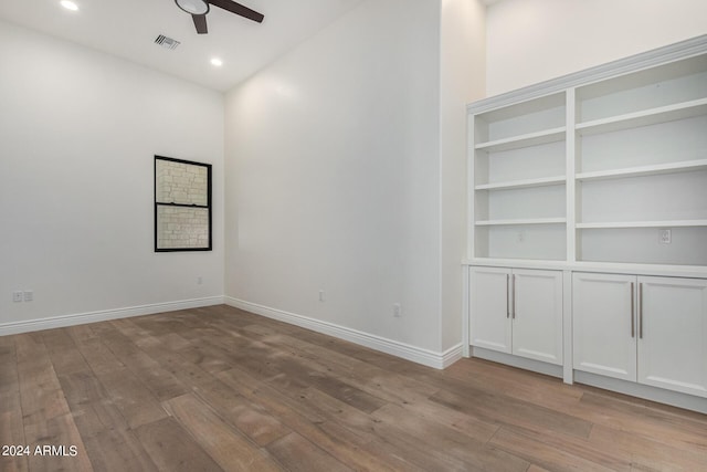 empty room with ceiling fan and light hardwood / wood-style flooring