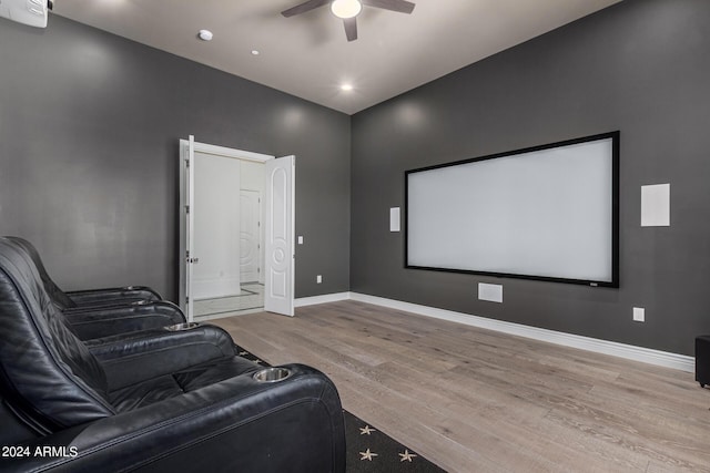 cinema with ceiling fan and light hardwood / wood-style flooring