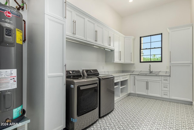 washroom featuring cabinets, sink, separate washer and dryer, and water heater