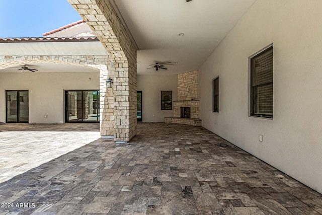 view of patio / terrace with an outdoor stone fireplace and ceiling fan