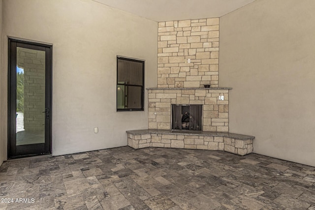 unfurnished living room featuring a stone fireplace