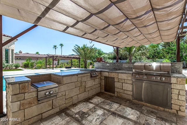 view of patio featuring area for grilling, a pergola, and sink