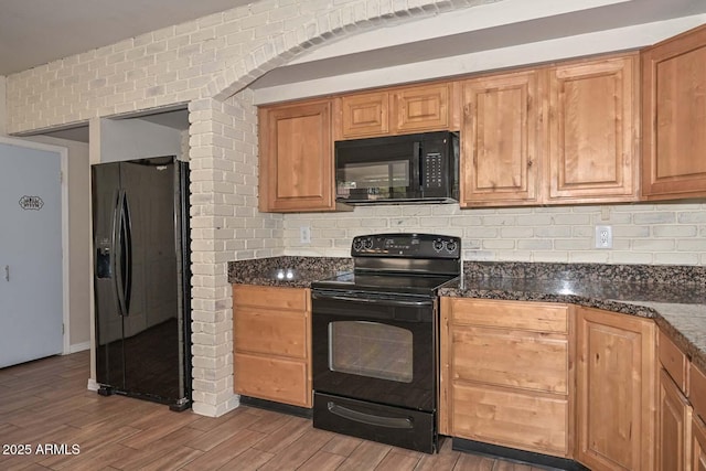 kitchen with decorative backsplash, black appliances, and wood finished floors