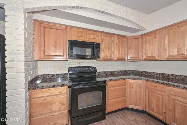 kitchen featuring tasteful backsplash, dark stone countertops, black appliances, and light wood-style floors