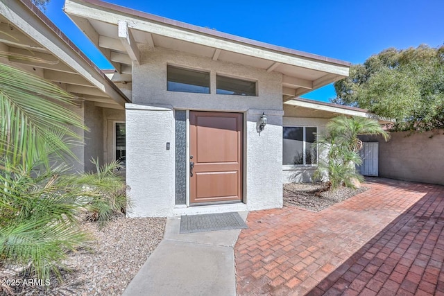 entrance to property featuring stucco siding