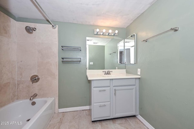 bathroom with vanity, washtub / shower combination, and baseboards